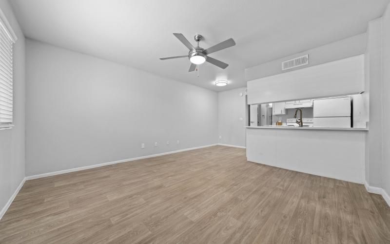 a room with a ceiling fan and a wood floor