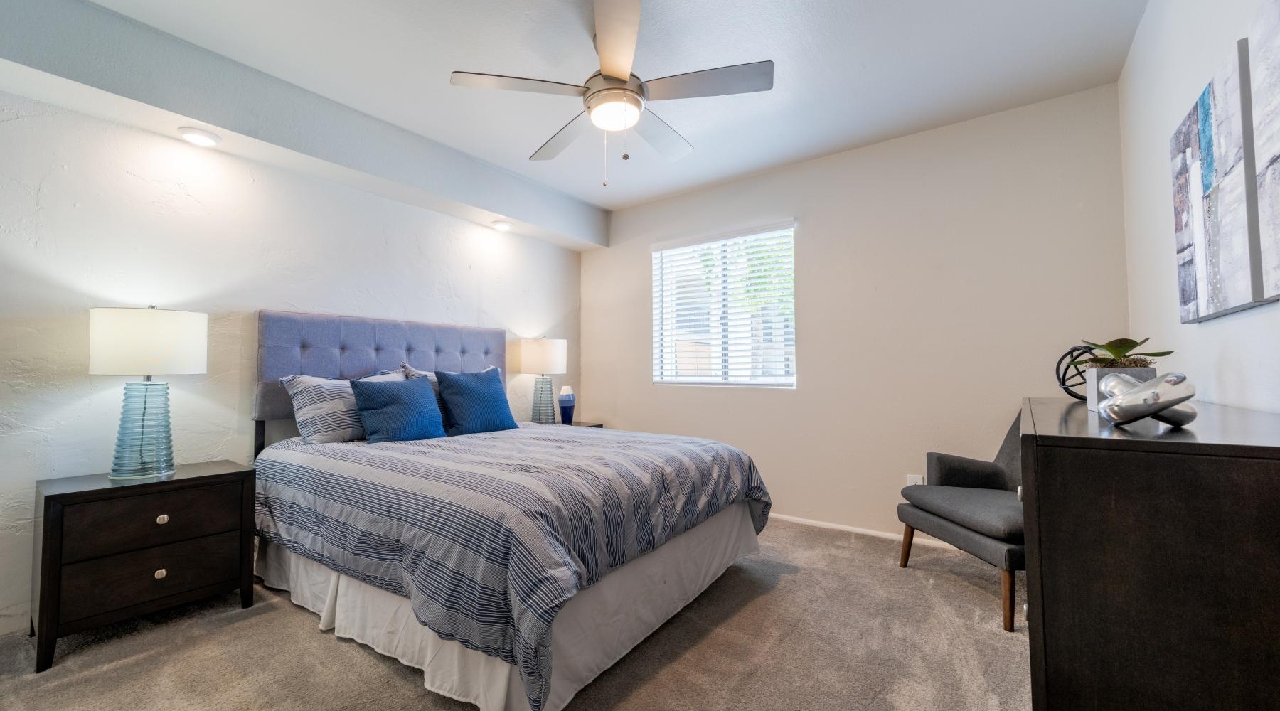 a bedroom with a bed and a fan